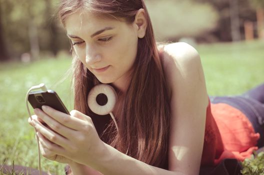 beautiful model young woman on the phone  in the park in spring