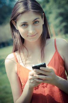 beautiful model young woman on the phone  in the park in spring