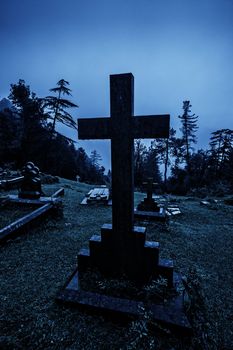 Spooky Halloween graveyard in fog in moonlight