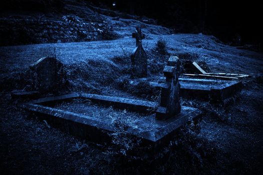 Spooky Halloween graveyard in fog in moonlight