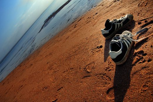 Two shoes of the traveller at the summer beach