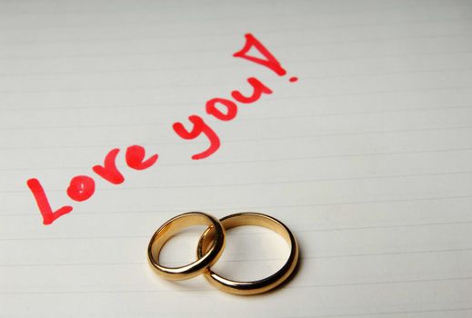 Loving letter with golden wedding rings