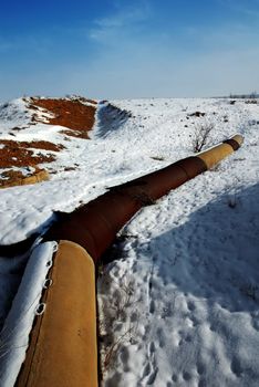 Rusted gas and oil pipeline under the snow