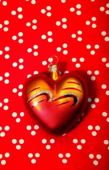 Toylike heart on a red background as a symbol of Valentine's Day or Christmas