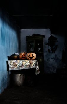 Two Halloween pumpkins in rural house with dark interior