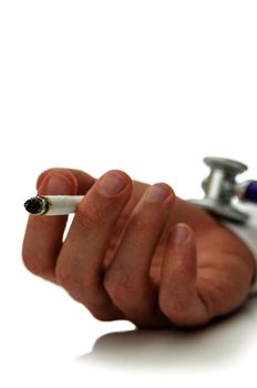 Stethoscope on smokers hand holding a cigarette. Concept of health risk smoking causes. Focus on a cigarette.