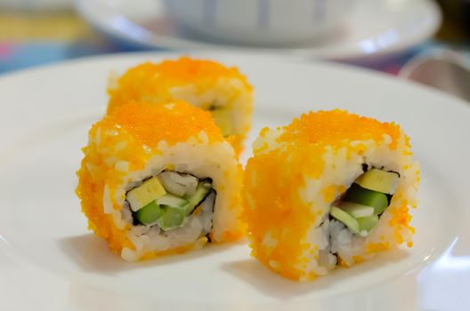 California Maki Sushi with Masago , Roll made of Crab Meat, Avocado, Cucumber, Japanese Mayonnaise inside. smelt roe outside on dish