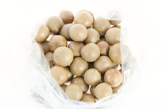 top view macadamia in plastic bag over white background
