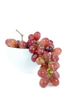 A bunch of red grapes in a white bowl