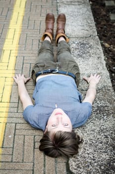 young beautiful hipster woman lying on the ground in the city