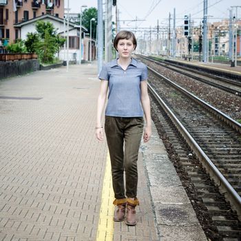 young beautiful hipster woman walking in a railway station