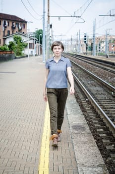 young beautiful hipster woman walking in a railway station