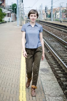 young beautiful hipster woman walking in a railway station