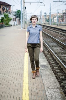 young beautiful hipster woman walking in a railway station