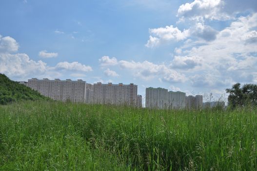 New buildings on the outskirts of Moscow. The building is hardly possible to find among the weeds.