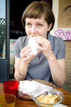 young beautiful hipster woman eating at the bar