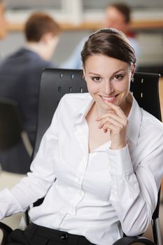 Beautiful young businesswoman with colleagues in the background