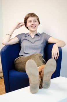 young beautiful hipster woman sitting in the armchair relaxing at home