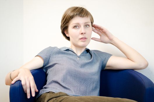 young beautiful hipster woman sitting in the armchair relaxing at home