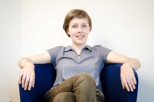 young beautiful hipster woman sitting in the armchair relaxing at home