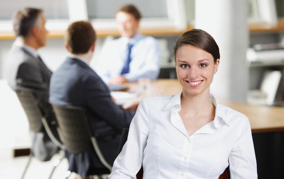 Happy businesswoman with colleagues in the background