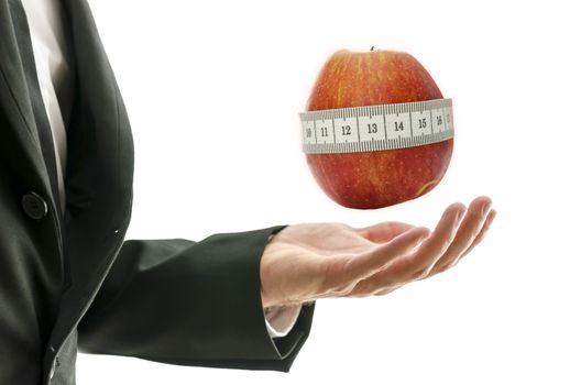 Male hand presenting apple wrapped with measuring tape.