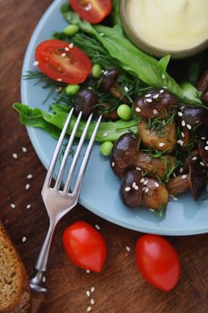 Fried mushrooms with fresh vegetables and herbs