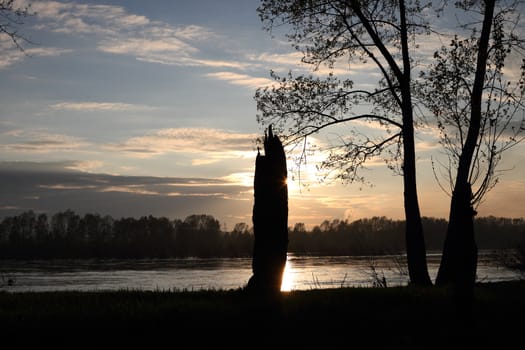 Kind on the river in the evening and a sunset