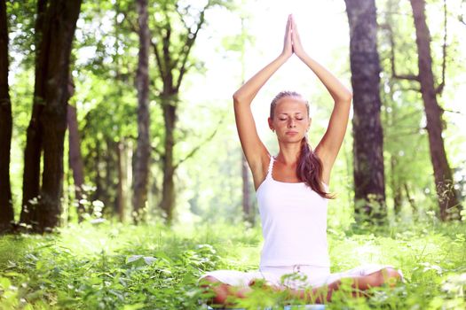 yoga woman on green grass in forest