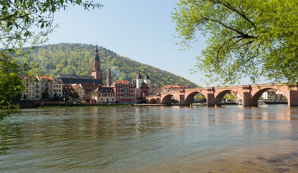 Medieval bridge leading into old town of Heidelberg Germany from riverbank of River Neckar