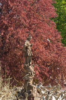 Statue of Saint John of Nepomuk by old bridge leading to ancient town city of Heidelberg Germany