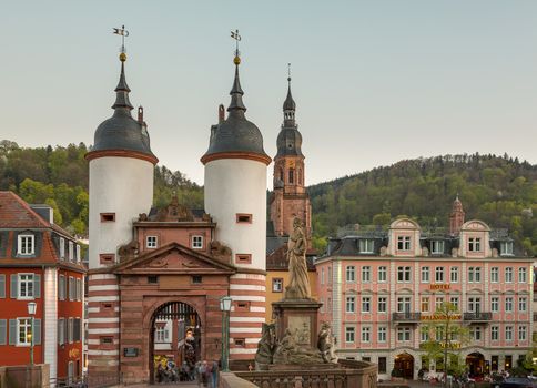 HEIDELBERG, GERMANY - APRIL 24: Tourists and locals stroll through gateway into old town on 24 April 2013. The bridge was built in 1786