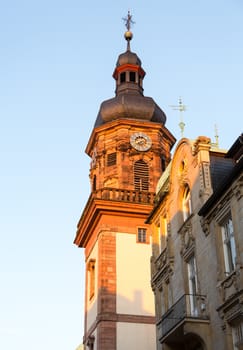 Old town city of Heidelberg Germany. Red brick church clock tower on main street hauptstrasse with onion roof