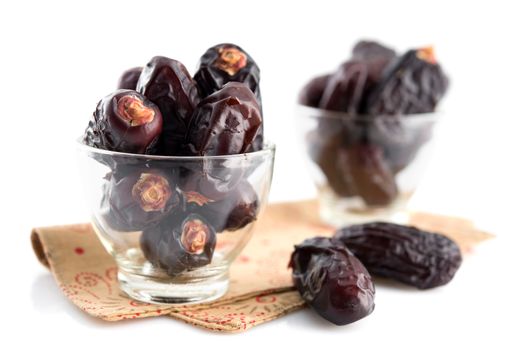 Dates fruit. Pile of fresh dried date fruits in glass isolated on white background.