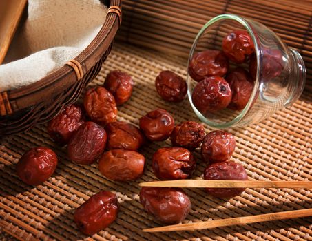 Dried red date or Chinese jujube. Traditional herbal medicine spill on bamboo mat.