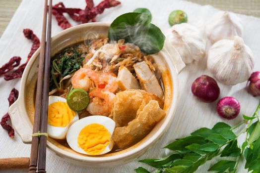 Prawn mee, prawn noodles. Famous Malaysian food spicy fresh cooked har mee in clay pot with hot steam, serve with chopsticks.