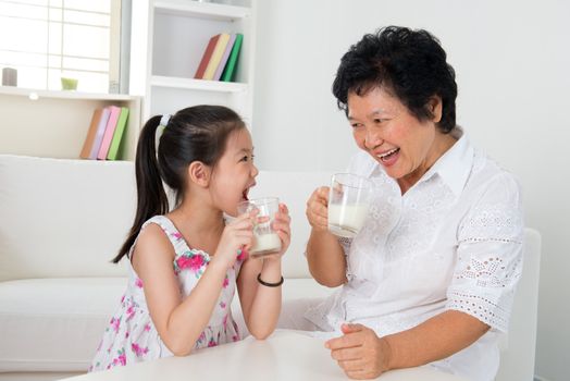 Drinking milk. Happy multi generations Asian family at home. Beautiful grandmother and granddaughter,  healthcare concept.