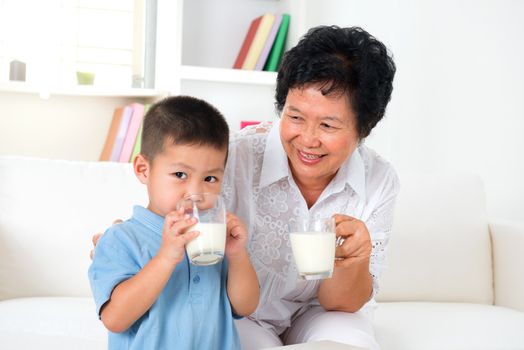Drinking milk. Happy multi generations Asian family drinking milk at home. Beautiful grandmother and grandson,  healthcare concept.