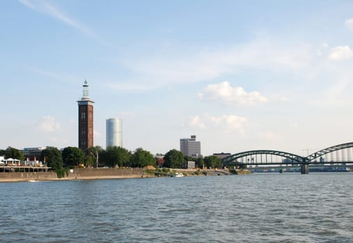 The Messeturm (Fair Tower), Triangle Tower and Hohenzollernbruecke (Hohenzollern Bridge) seen from the Rhine in Cologne, Germany