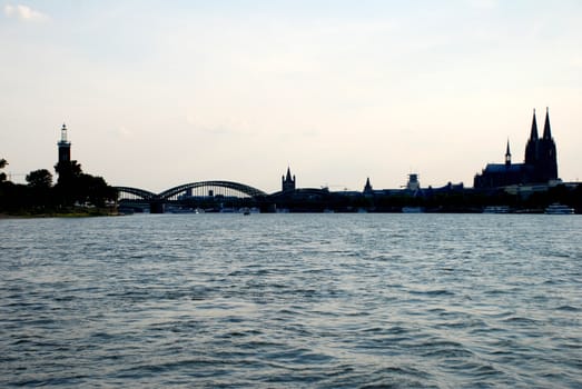 Distinctive Cologne cityscape in silhouette seen from the Rhine river