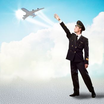 pilot in the form of extending a hand to a flying airplane on the background of clouds and sun