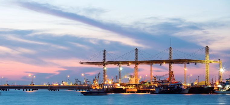 Panorama of Container stacks and crane in shipyard at dusk for cargo Goods and Logistic background