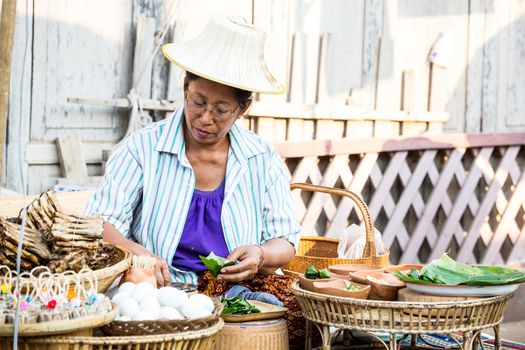 SUKHOTHAI, THAILAND - MAY 4: Unidentified mature woman is selling Thai traditional snack on May 4, 2013 at Rim Yom 2437 night market, Sukhothai, Thailand.
