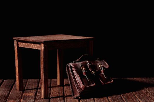 a vintage bag under an old and wooden table