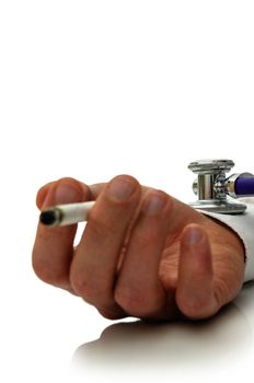 Stethoscope on smoker hand holding a cigarette. Concept of health problems smoking causes. Focus on stethoscope.