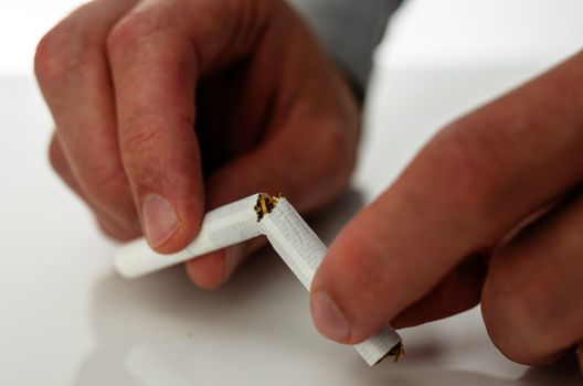 Male hands breaking a cigarette. Concept of breaking smoking addiction.