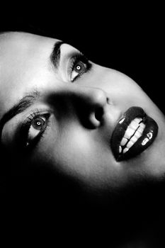 Beautiful lady with perfect dramatic makeup on a dark background