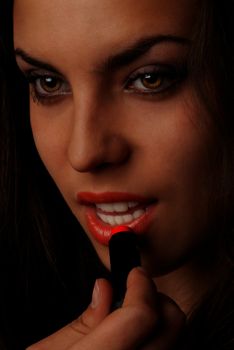 Beautiful lady applying lipstick
