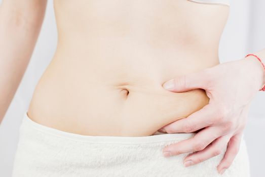 young woman holding her skin for cellulite check