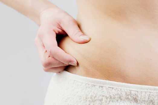 young woman holding her skin for cellulite check